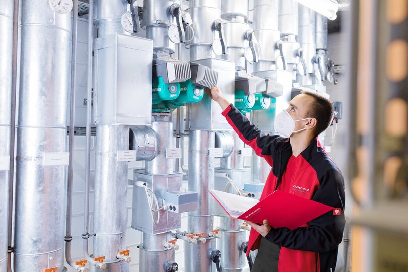 Techniker der Gebäudetechnik prüft Pumpenanlage