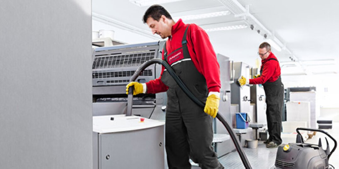 Reinigungskraft reinigt Industrieanlage