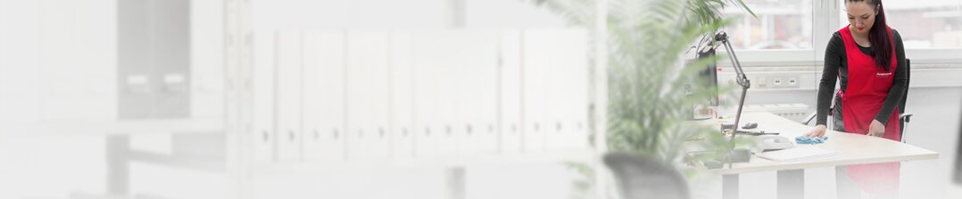 Reinigungskraft wischt einen Tisch im Büro